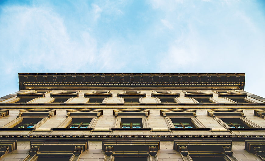 Low angle view of classical building facade against blue sky