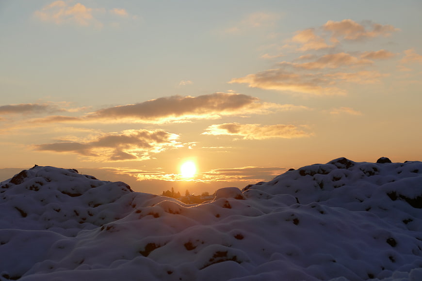Golden sunset over snowy landscape with dramatic clouds