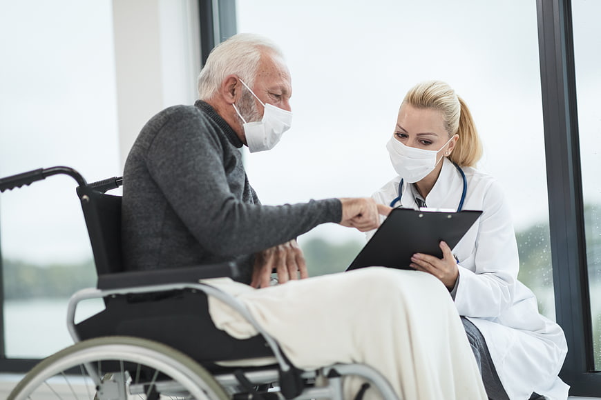 Senior Patient in Wheelchair Consulting with Doctor