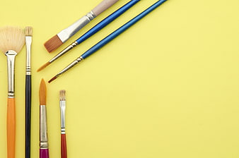 Assorted Paint Brushes on Yellow Background