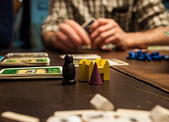 Close-up of wooden board game pieces and cards on a table