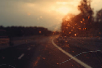 Blurred Sunset Road View Through Rainy Car Window