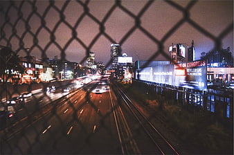 Night City Highway View Through Chain Link Fence