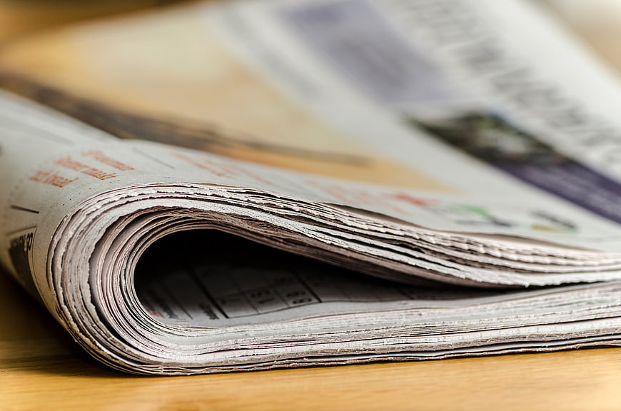 Close-up of folded newspaper pages on wooden table