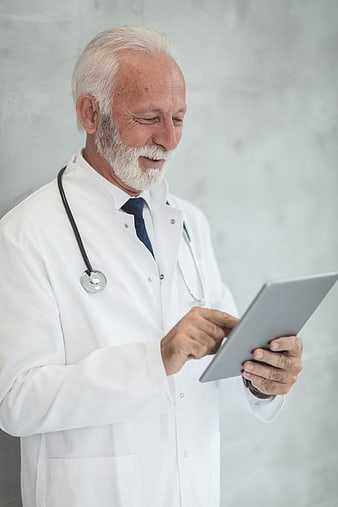 Senior male doctor using tablet in white coat
