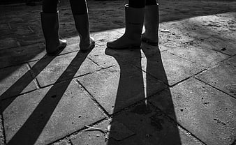 Black and white photo of two people wearing rain boots