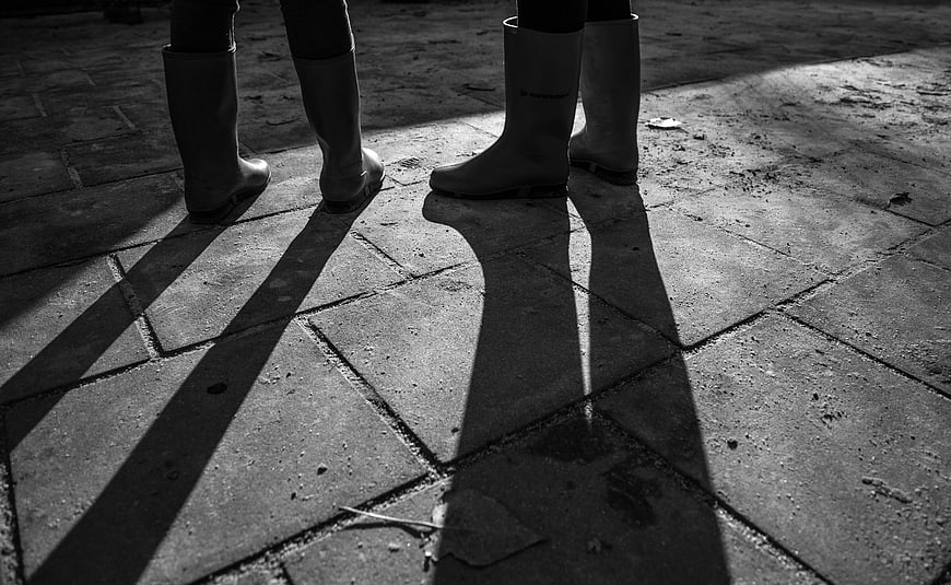Black and white photo of two people wearing rain boots