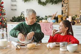 Grandmother and granddaughter baking Christmas cookies together in kitchen