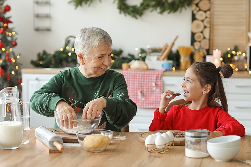 Grandmother and granddaughter baking Christmas cookies together in kitchen