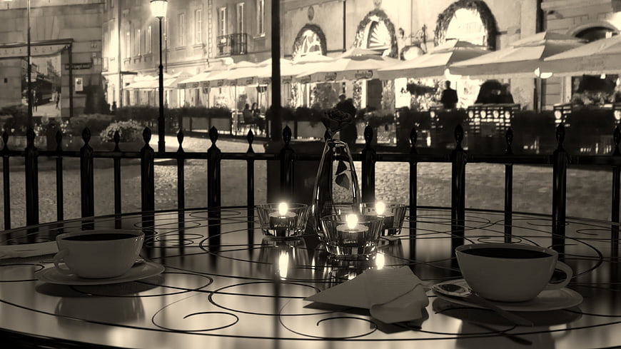 Romantic black and white cafe table with candles at night