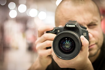 Close-up of Photographer Holding DSLR Camera with Lens