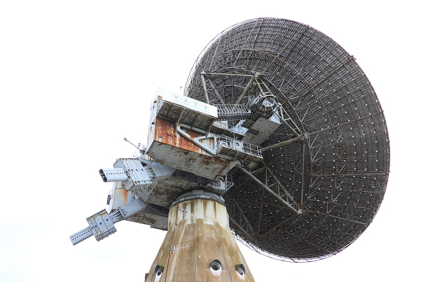 Low angle view of a large rusted radio telescope antenna dish