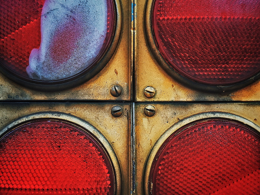 Close-up of vintage red traffic light lenses and metal housing