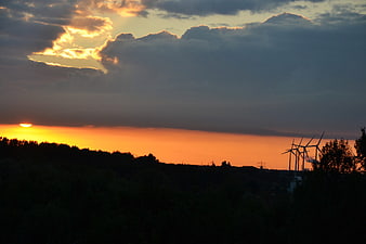 Sunset Silhouette of Wind Turbines and Forest
