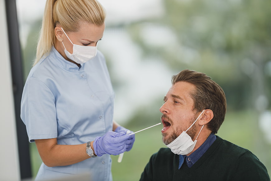 Nurse performing nasal swab test on male patient