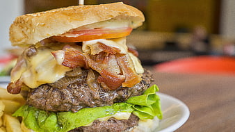 Close-up of gourmet bacon cheeseburger with fries