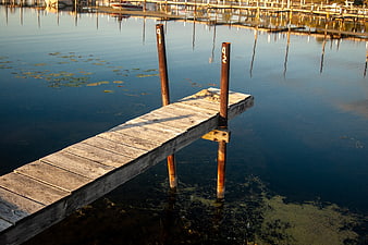 Weathered wooden pier extending into calm blue water