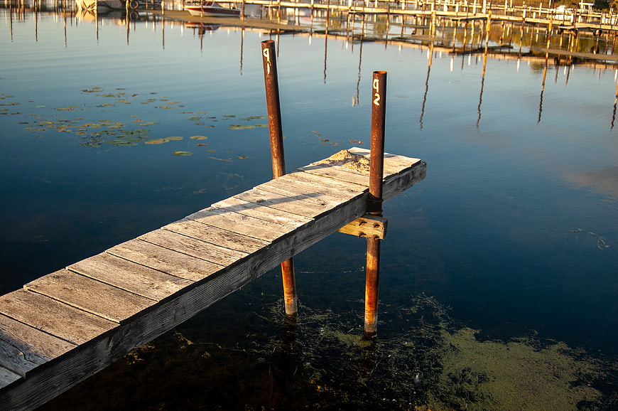 Weathered wooden pier extending into calm blue water