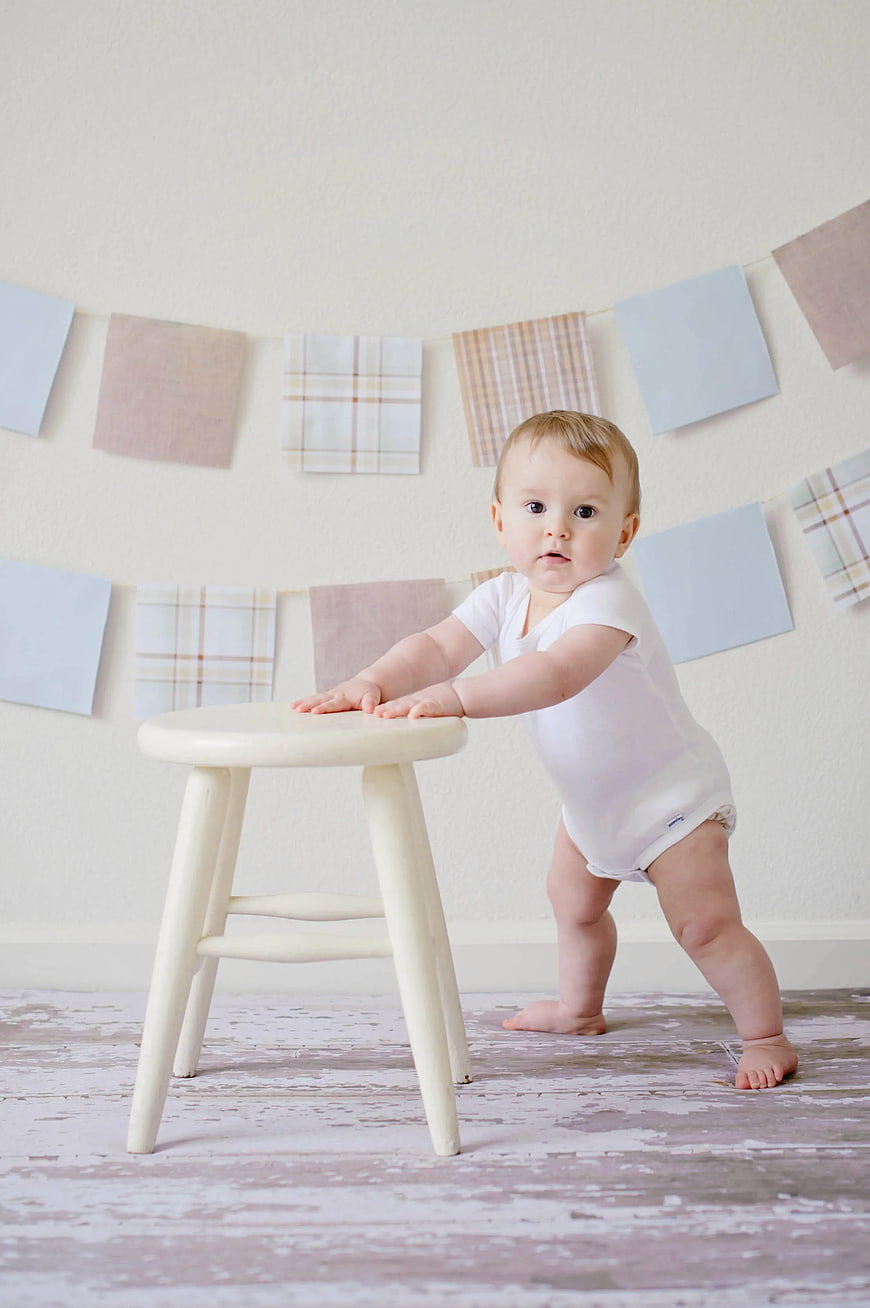 Baby Learning to Walk Holding White Wooden Stool