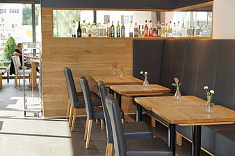 Modern Restaurant Interior With Wooden Tables And Black Leather Seating