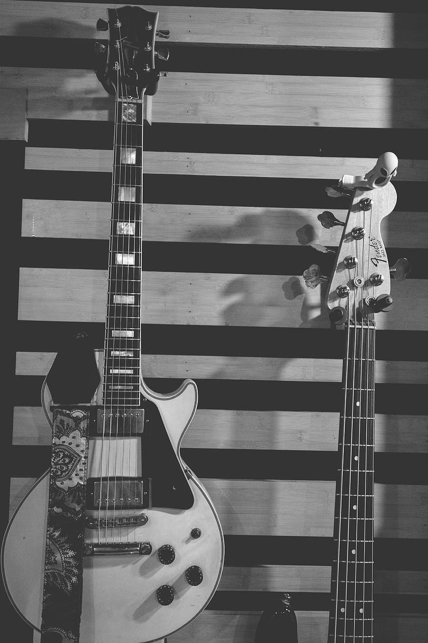 Black and White Electric Guitars on Wooden Wall