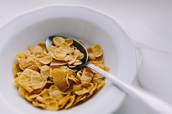 Close-up of Corn Flakes in White Bowl with Spoon