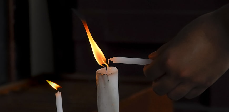 Hand Lighting White Candle Flame Close Up