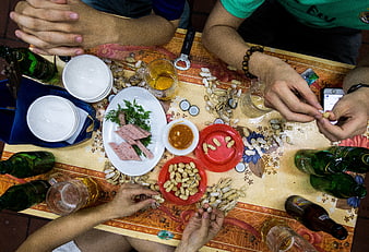 Top view of friends sharing beer and peanuts at a table