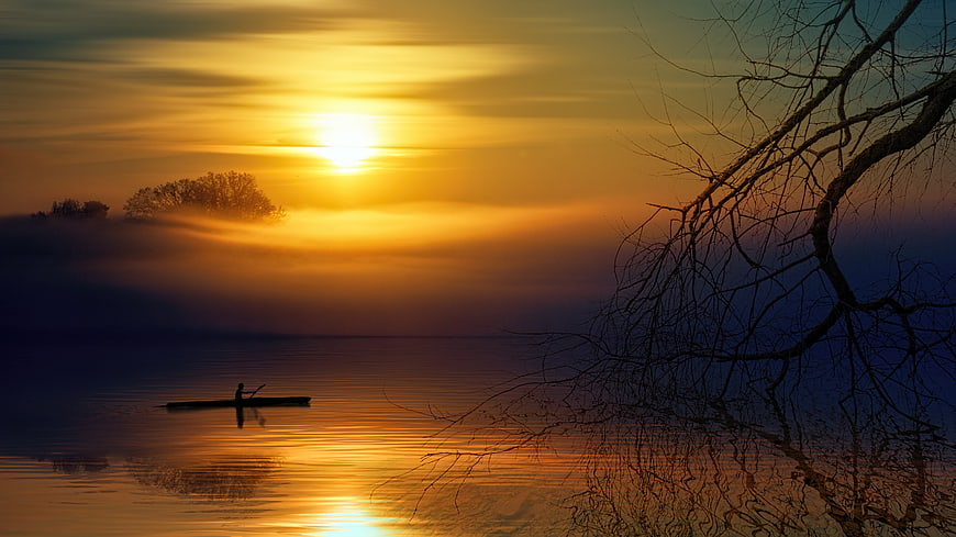 Silhouette of Kayaker on Misty Lake at Golden Sunrise