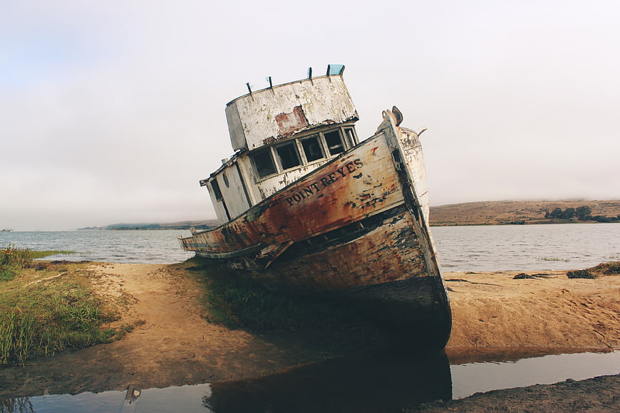 Abandoned Rusty Boat Wreck on Sandy Shore