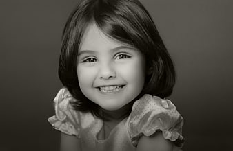 Black and white portrait of a smiling young girl with short hair