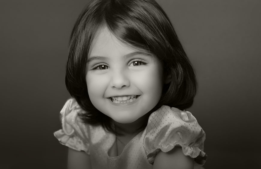 Black and white portrait of a smiling young girl with short hair