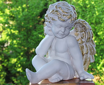 White Angel Statue With Gold Wings On Garden Pedestal