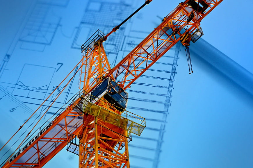 Orange Tower Crane Against Blue Blueprint Background