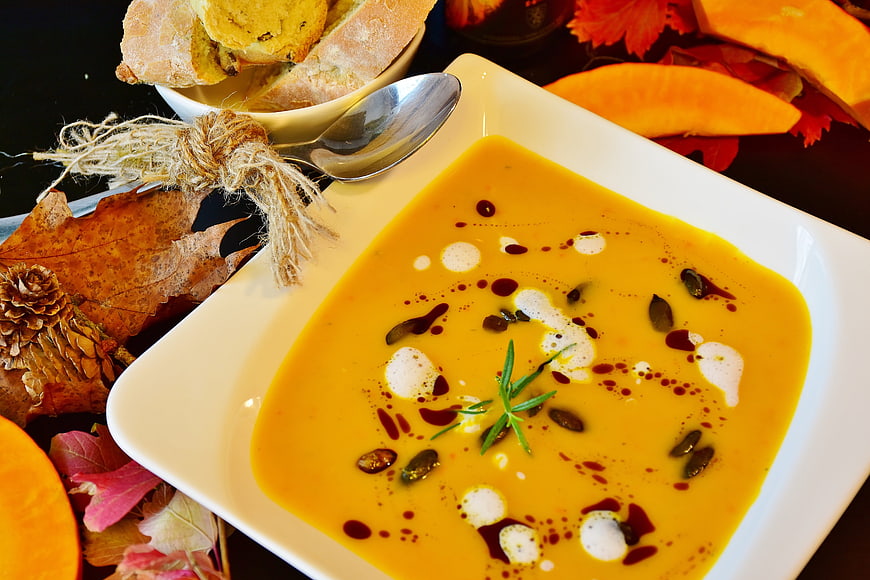Creamy Pumpkin Soup with Seeds and Rosemary Garnish