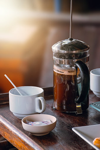 French press coffee maker with white ceramic cup on rustic wooden table