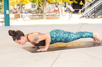 Woman doing plank exercise on yoga mat outdoors