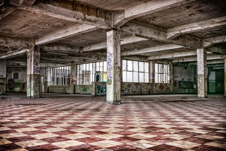 Abandoned Factory Interior with Checkered Floor and Graffiti
