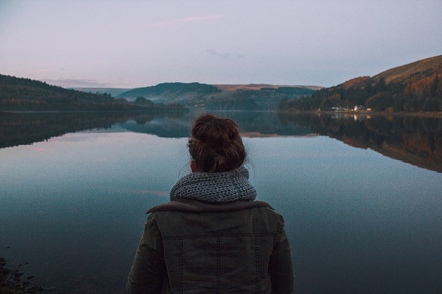 Woman in Scarf Looking at Lake at Dusk