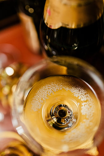 Top-down view of champagne glass with bubbles and bottle