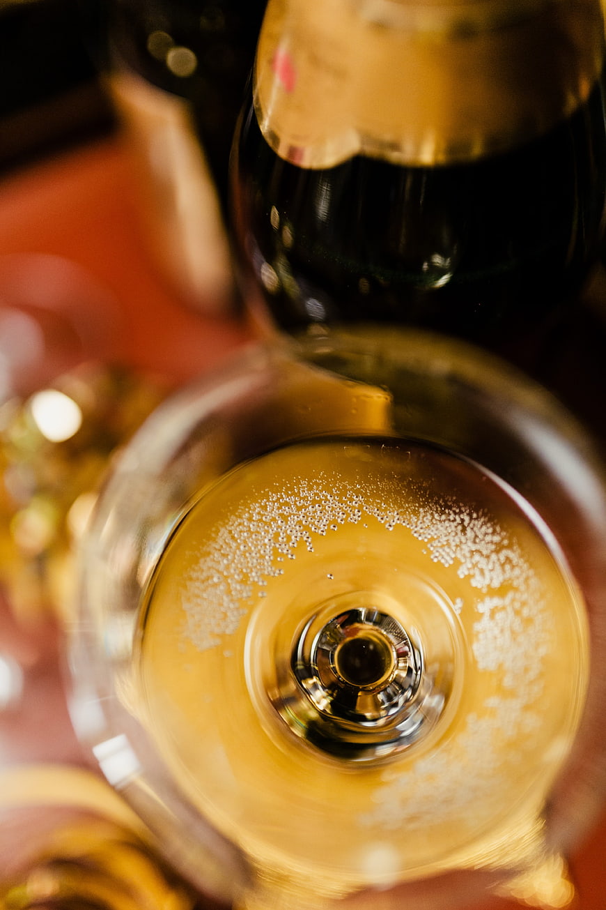 Top-down view of champagne glass with bubbles and bottle