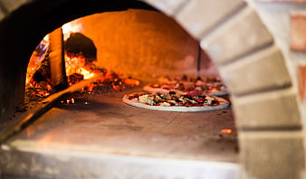 Wood-fired pizza baking in a traditional brick oven
