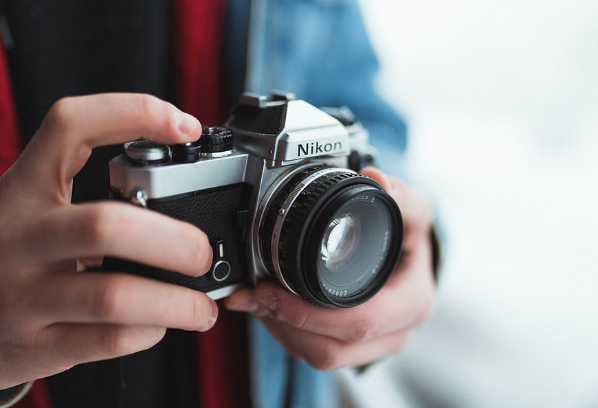 Close-up of Hands Holding Vintage Nikon Film Camera