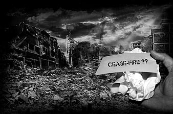 Hand holding cease-fire sign in war-torn urban ruins