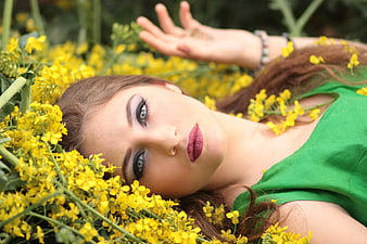 Young Woman Lying in Yellow Flower Field