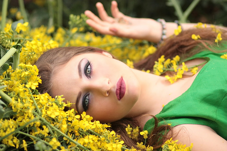 Young Woman Lying in Yellow Flower Field