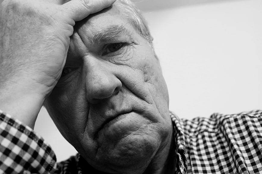 Close-up of elderly man looking sad and exhausted