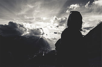 Silhouette of Woman Looking at Mountain Sunbeams