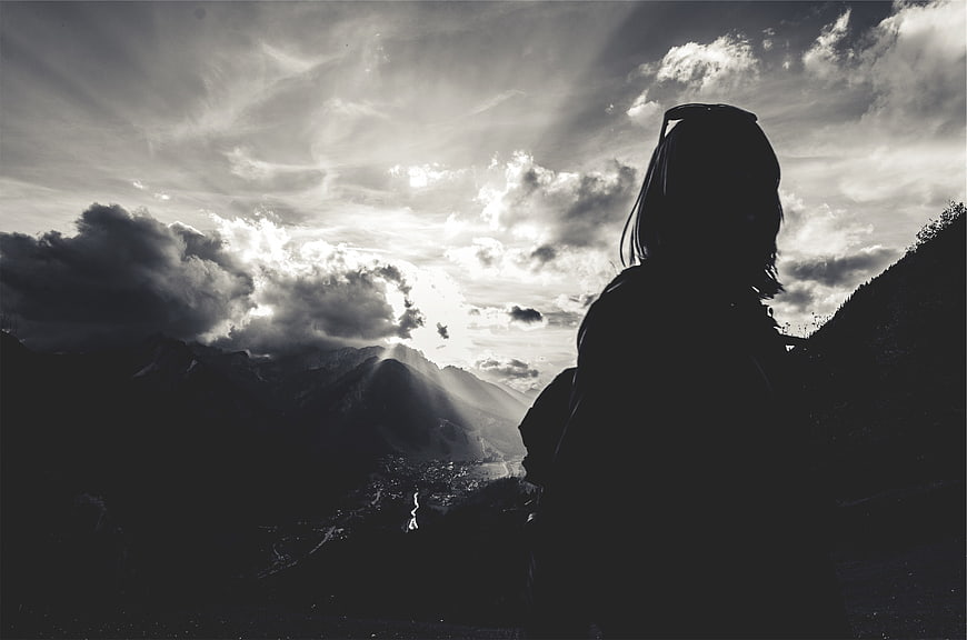 Silhouette of Woman Looking at Mountain Sunbeams