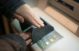 Close-up of hand using ATM keypad for cash withdrawal